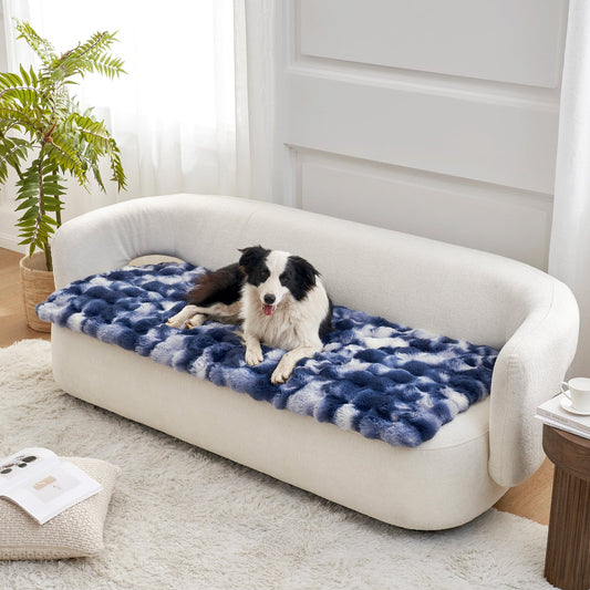 Dog lying on a tie-dye blue couch cover on a white couch in a bright room.#color_Tie-dye Blue