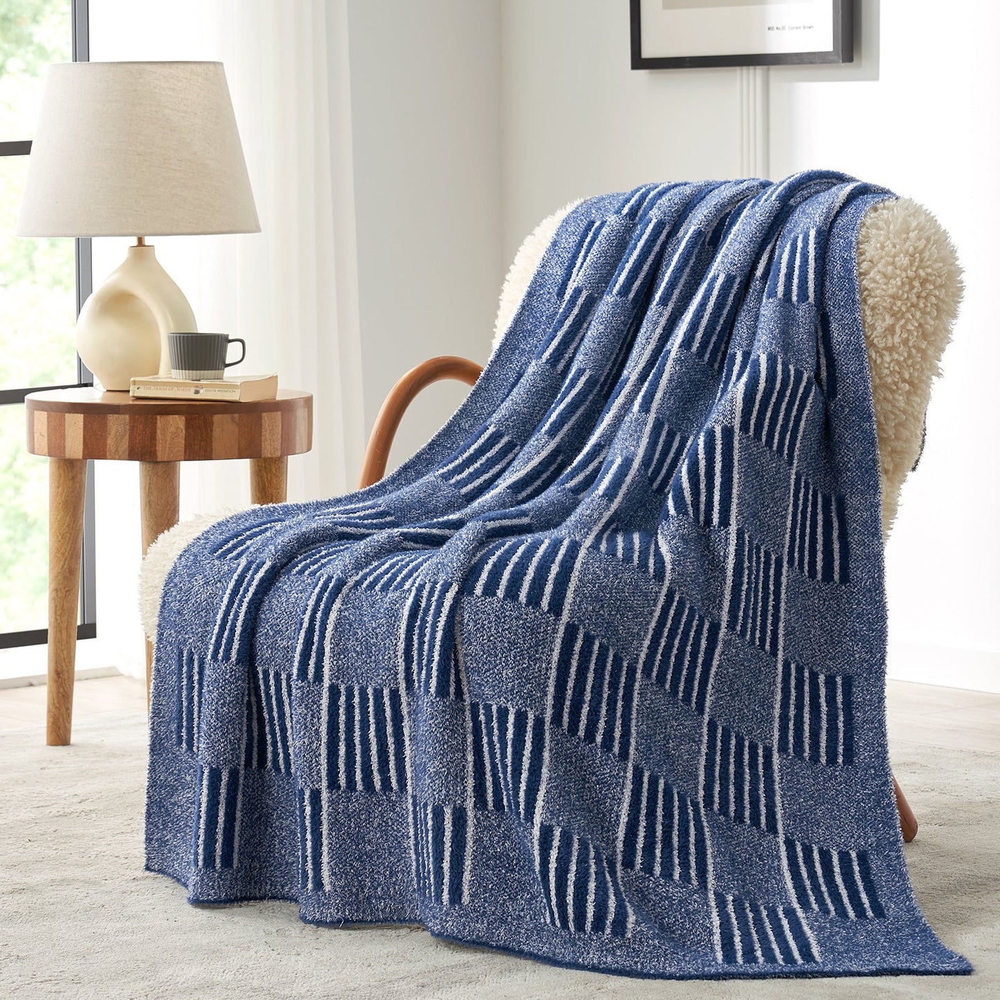 Reversible Heather Checkered Feather Yarn Throw Blanket in Navy draped over an armchair, showcasing its soft texture and modern checkered pattern design. #color_Navy