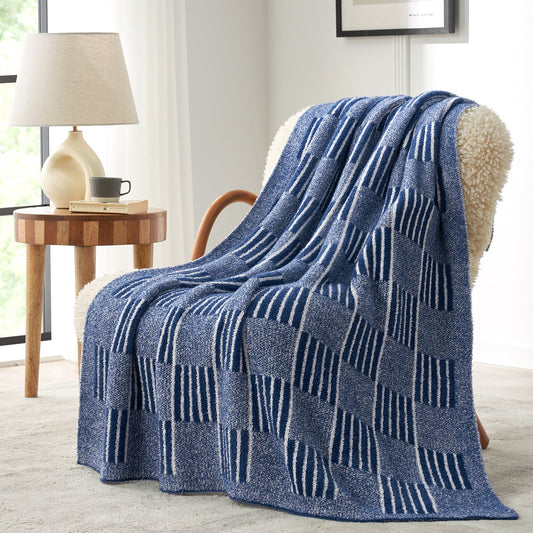 Reversible Heather Checkered Feather Yarn Throw Blanket in Navy draped over an armchair, showcasing its soft texture and modern checkered pattern design. #color_Navy