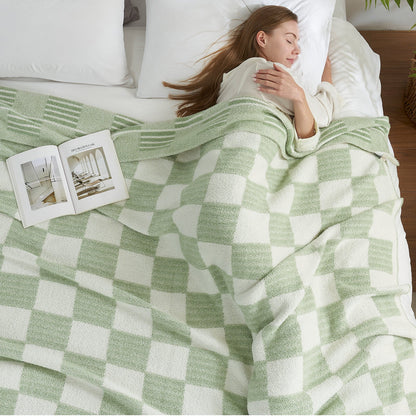 Woman sleeping comfortably under a Reversible Heather Checkered Feather Yarn Throw Blanket in Sage Green, perfect for everyday use. #color_Sage Green