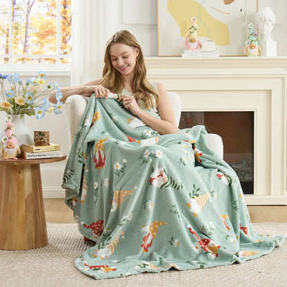 Woman relaxing on a chair with a spring gnomes milkyplush throw blanket in Green, enjoying soft and cozy comfort #color_Green