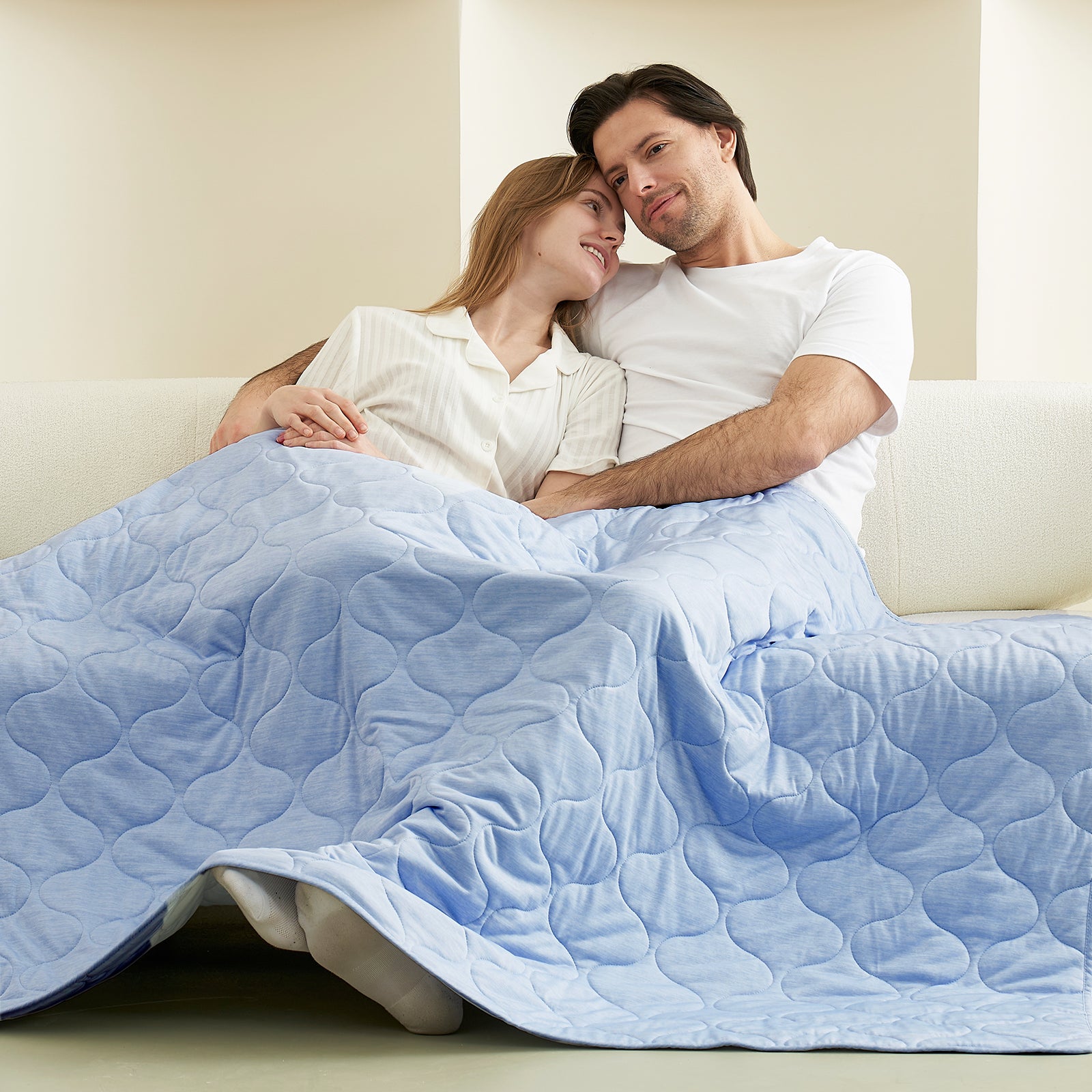 Couple relaxing under a cool blue cooling blanket on a sofa, cozy bedding #color_Cool Blue