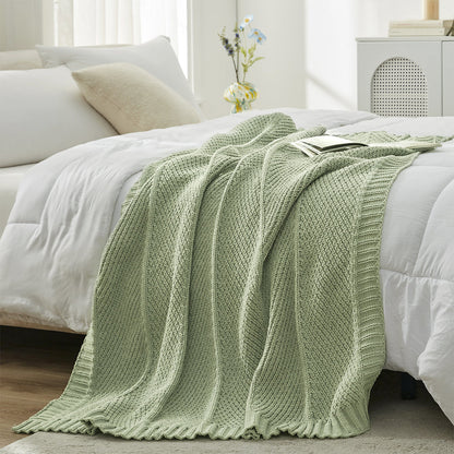 Chevron Chenille Knit Throw Blanket in Sage Green styled on a bed, adding a fresh and calming touch to decor. #color_Sage Green