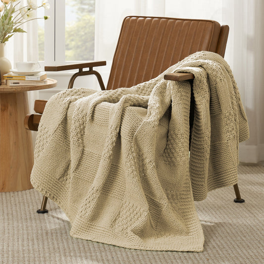 Checkered Chenille Knit Throw Blanket in Beige draped over a lounge chair, showcasing soft chenille knit texture and cozy checkered design. #color_Beige