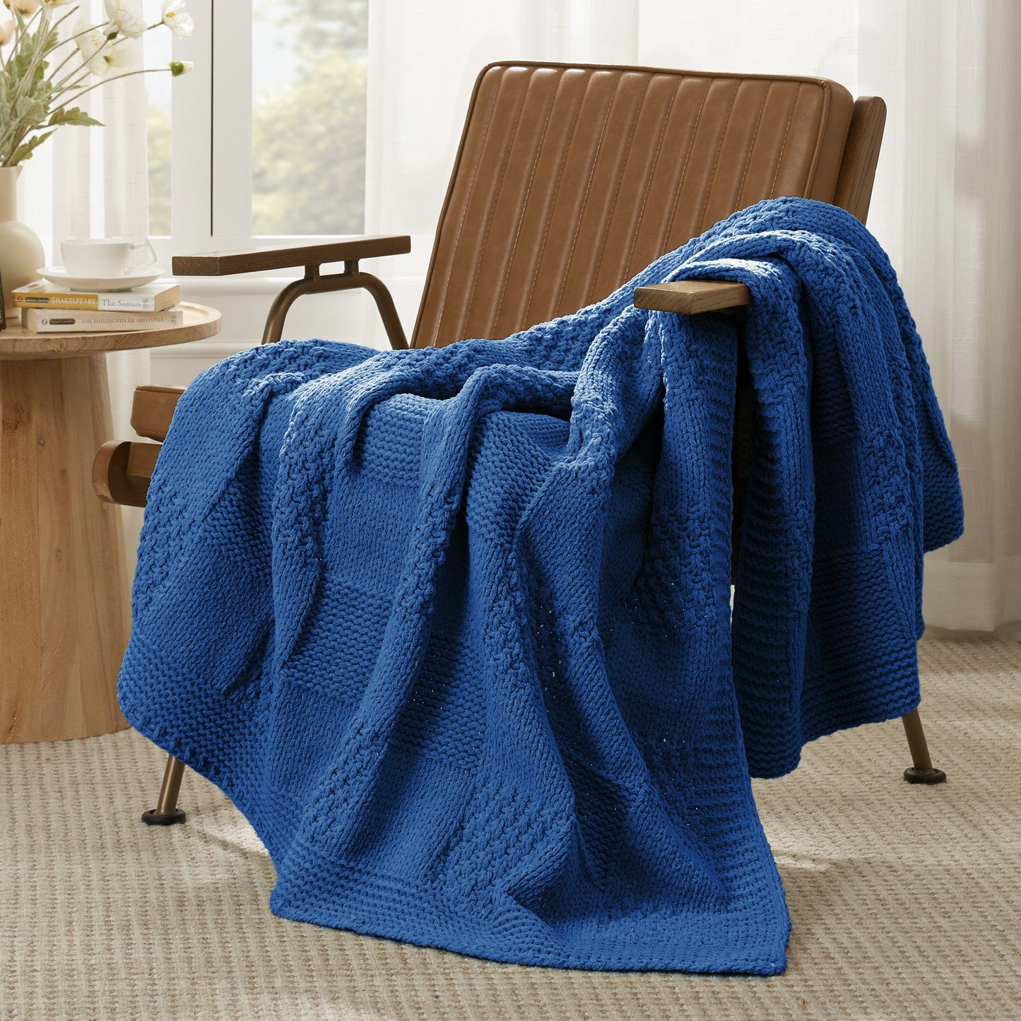 Checkered Chenille Knit Throw Blanket in Blue draped over a lounge chair, showcasing soft chenille knit texture and cozy checkered design. #color_Blue