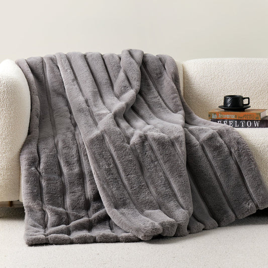 Cozy Bliss sheared faux fur throw blanket draped over a sofa, showcasing elegant ribbed texture #color_Grey