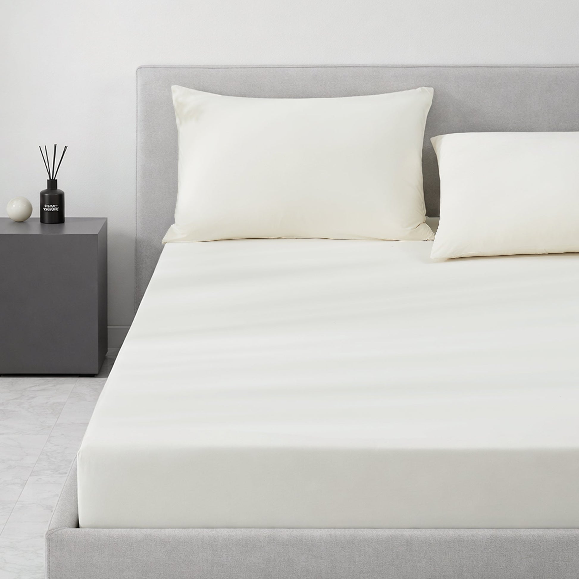 Gray cooling bedding set on a bed in a minimalistic bedroom setting.#color_Ivory