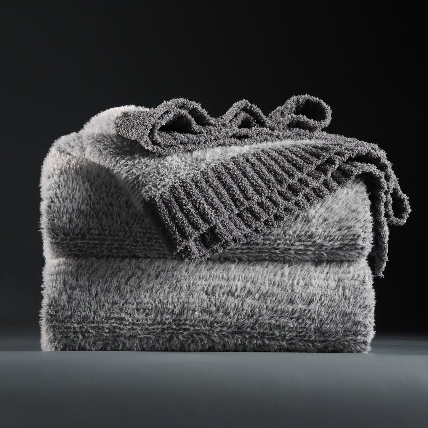 Faux Mink Feather Knit Throw Blanket in Grey neatly folded stack, showcasing soft feather yarn and premium texture. #color_Grey