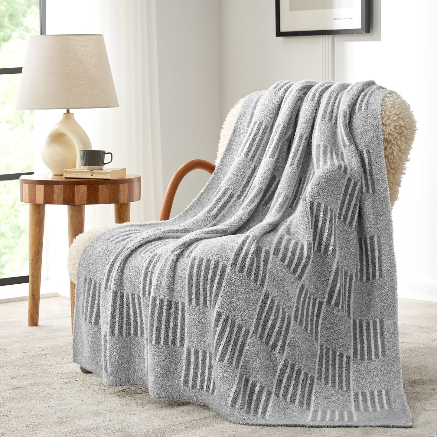 Reversible Heather Checkered Feather Yarn Throw Blanket in Grey draped over an armchair, showcasing its cozy texture and modern pattern. #color_Grey