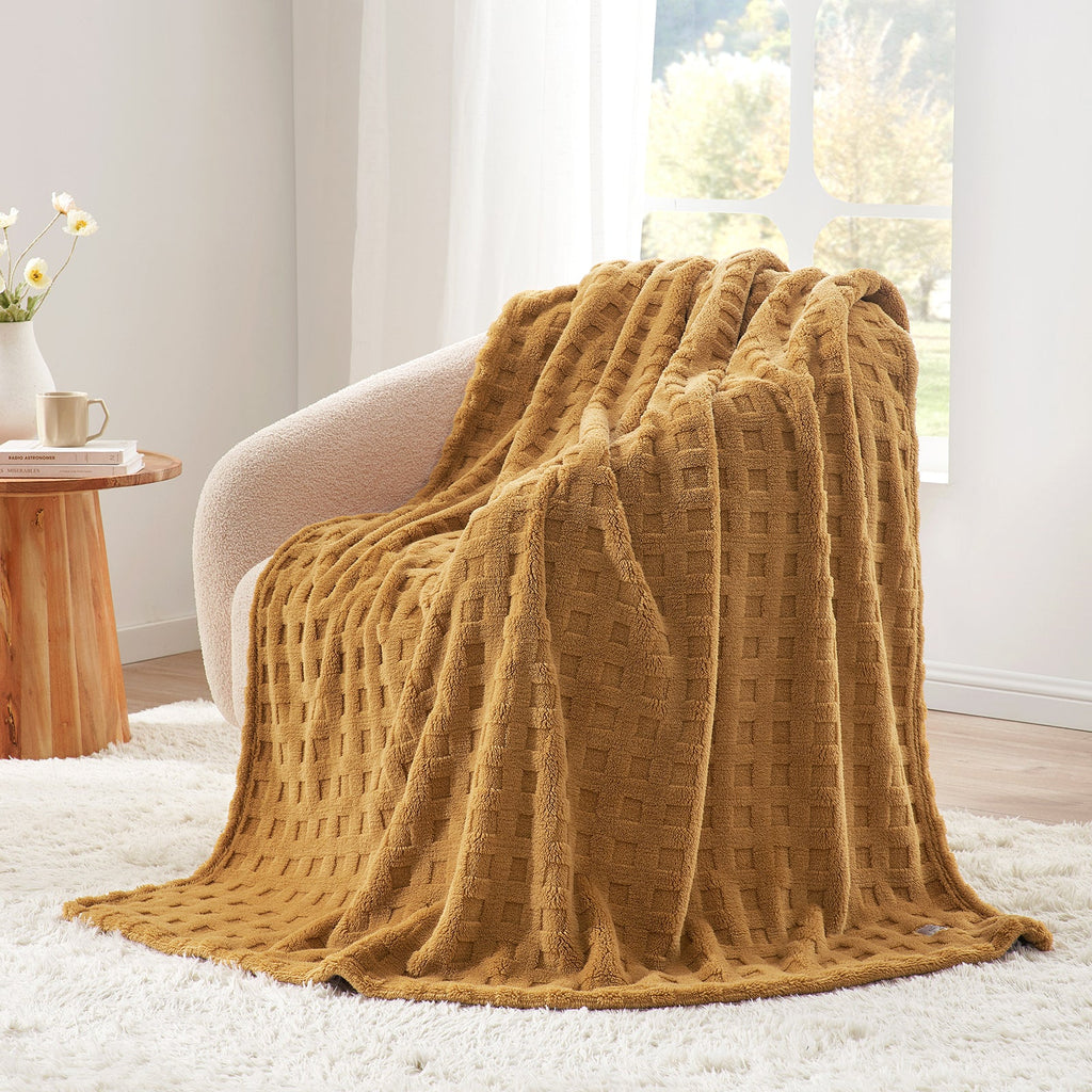 Checkered waffle shaggy sherpa throw blanket in Brown draped over an armchair, creating a clean and cozy corner #color_Brown