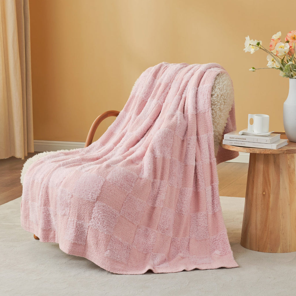Checkered Faux Fur Feather Yarn Throw Blanket in Pink draped over an armchair, adding a soft and cozy vibe. #color_Pink