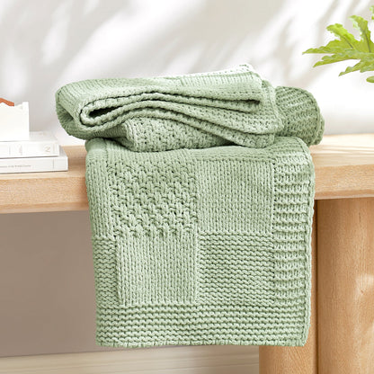 Checkered Chenille Knit Throw Blanket in Sage Green neatly folded on a table, showcasing detailed knit texture and soft chenille fabric. #color_Sage Green