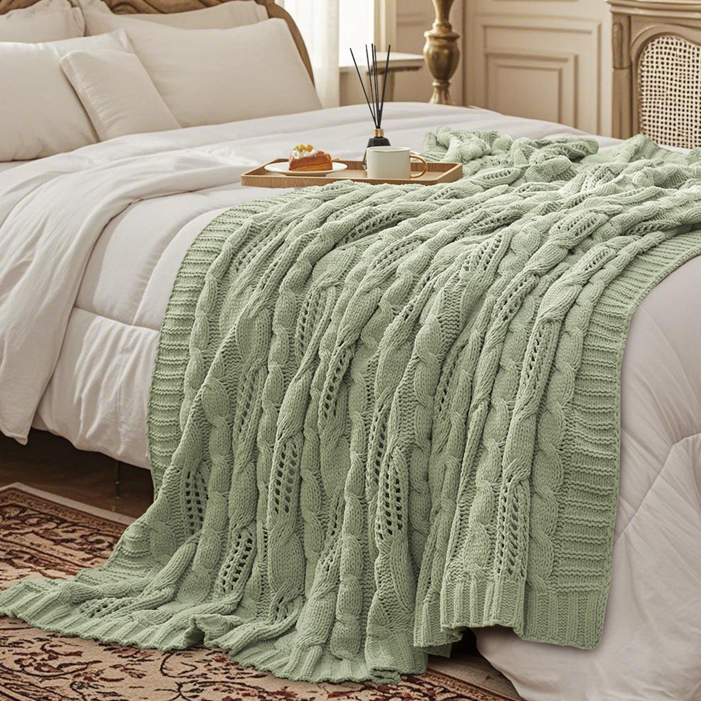 Chenille Cable Knit Throw Blanket in Sage Green styled on a bed in a cozy bedroom, adding a calm and inviting atmosphere. #color_Sage Green