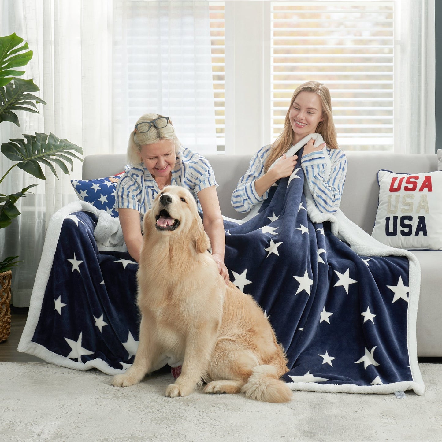 Family sitting on sofa with a navy blue star sherpa blanket in Navy Blue, enjoying a warm and cozy moment with their dog #color_Navy Blue