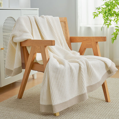 Chenille Waffle Knit Throw Blanket in Ivory draped over an armchair, creating a warm, inviting and stylish home atmosphere. #color_Ivory