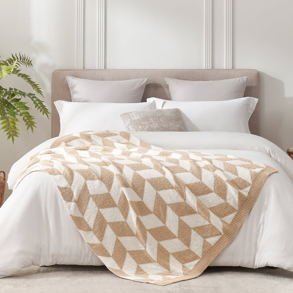 Chevron Feather Yarn Knit Throw Blanket in Beige styled on a bed, highlighting soft texture and modern chevron pattern in a bright bedroom setting. #color_Beige