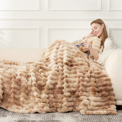 Woman reading on a couch wearing Striped faux fur blanket in tie-dye beige. #color_Tie-dye Beige