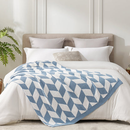 Chevron Feather Yarn Knit Throw Blanket in Blue styled on a bed, highlighting soft texture and modern chevron pattern in a bright bedroom setting. #color_Blue