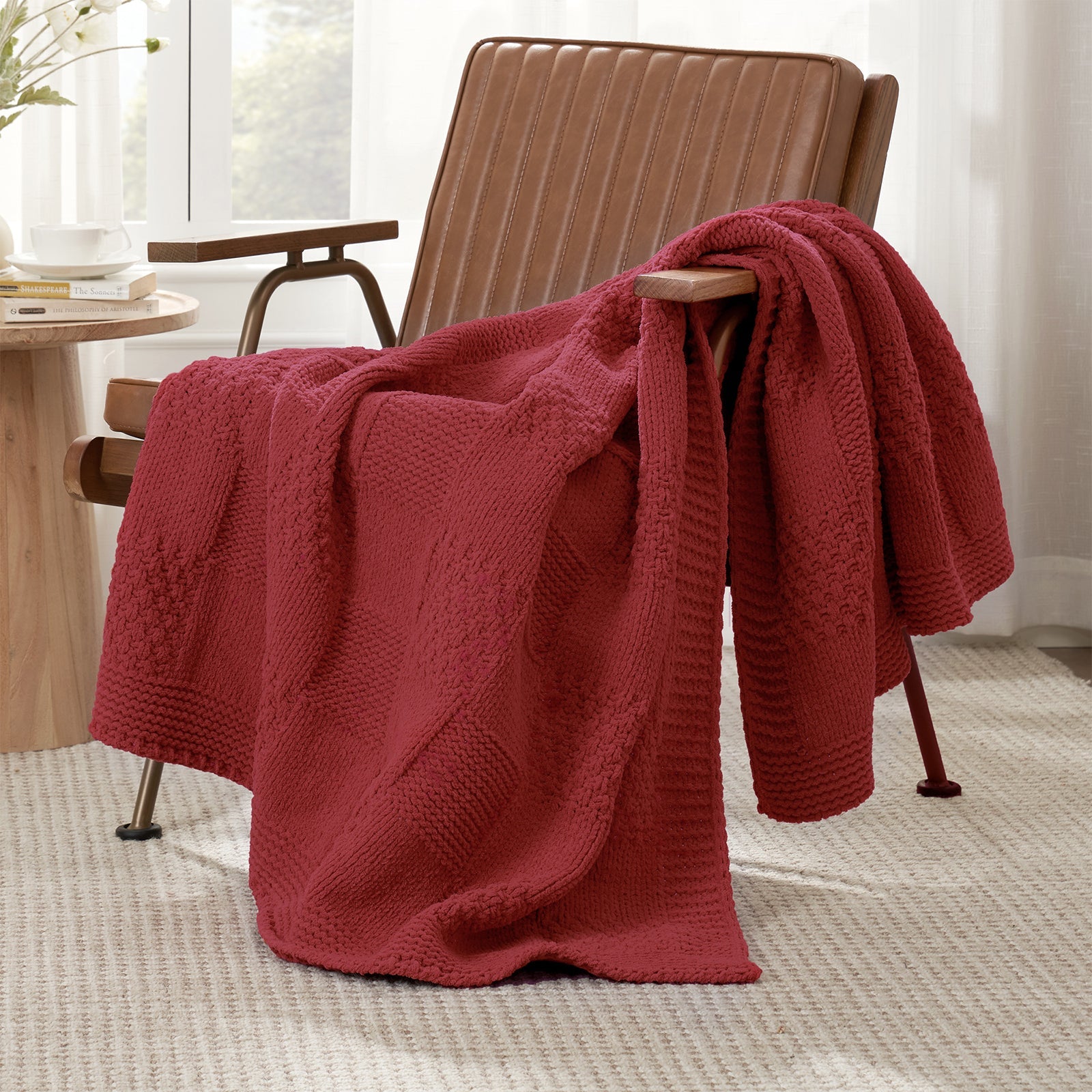 Checkered Chenille Knit Throw Blanket in Red draped over a lounge chair, showcasing soft chenille knit texture and cozy checkered design. #color_Red