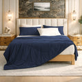 Cozy Bliss Dark Blue Cloud-like extra cooling comforter on bed in cozy bedroom.#Color_Navy Blue