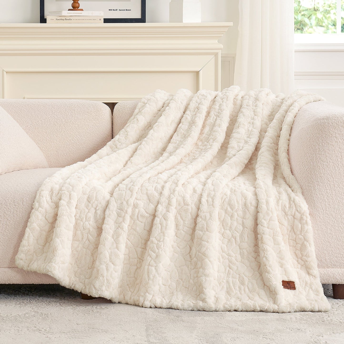 White textured blanket draped over a beige sofa in a bright room. #color_Cream White