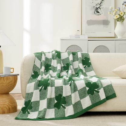 Green and white checkered blanket with shamrocks on a beige sofa in a living room in front view #color_Lucky Clover