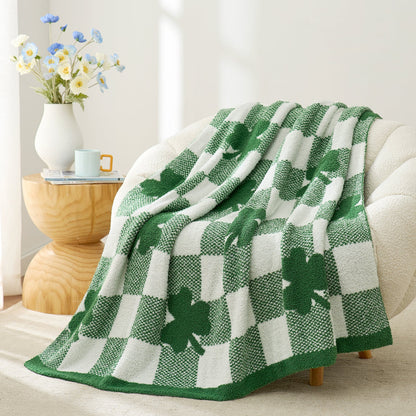 Green and white checkered blanket with shamrock pattern draped over a sofa in a cozy living room. #color_Lucky Clover
