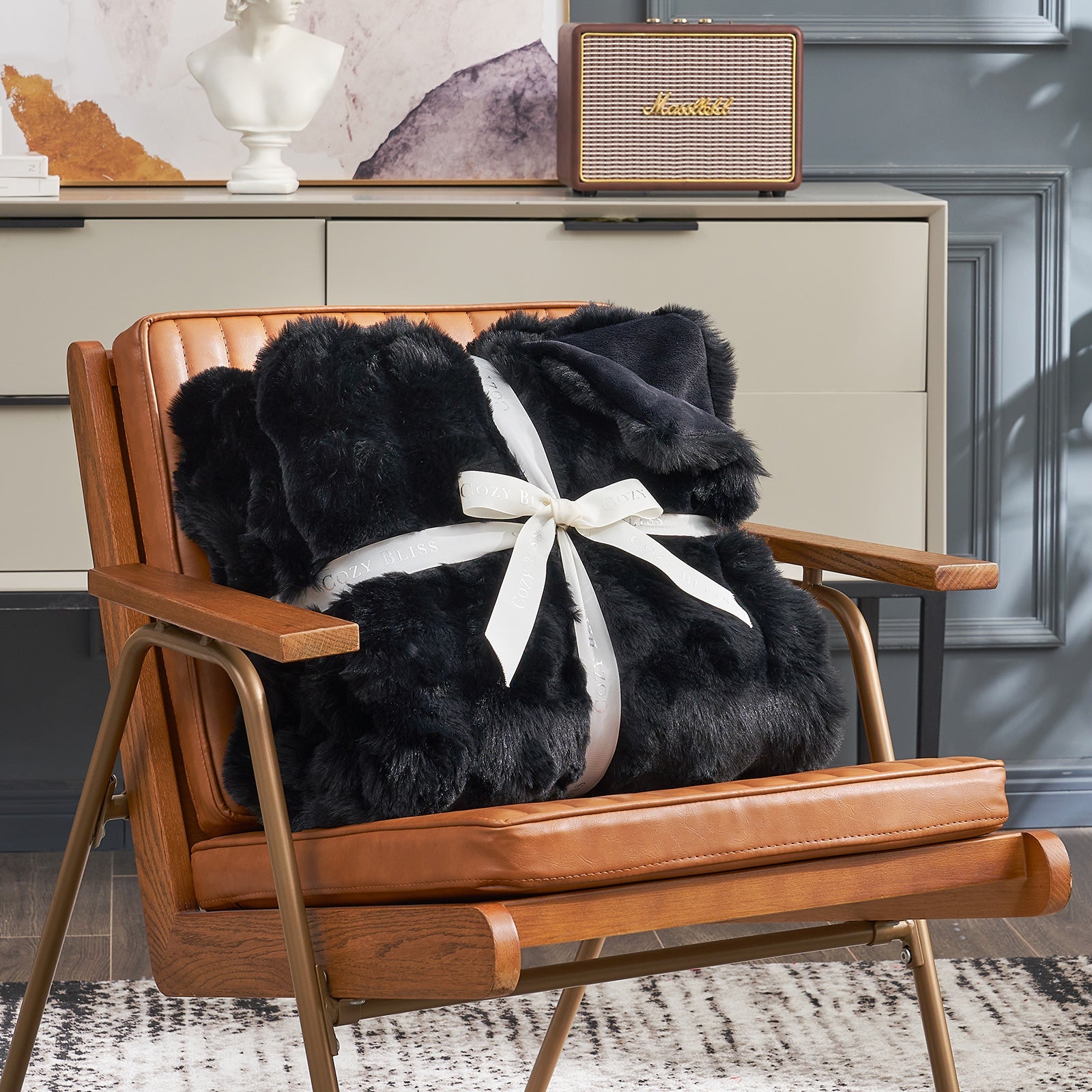 Fluffy black blanket with a bow on an armchair. #color_Black