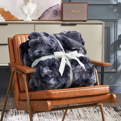 Cozy Bliss tie-dye faux fur throw blanket on an armchair #color_Tie-dye Black