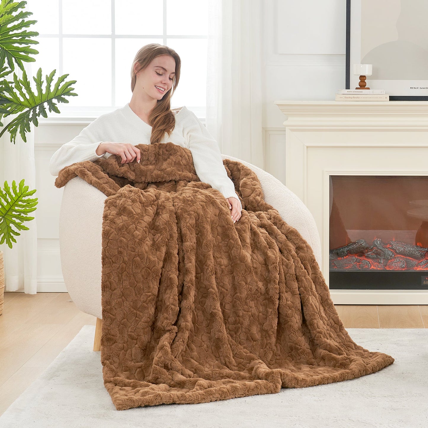 Woman sitting on a couch with a brown blanket, fireplace in the background #color_Brown