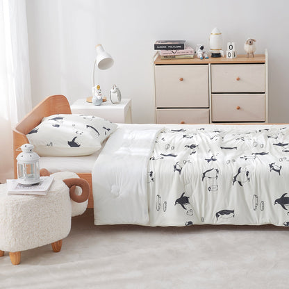 Bedroom with a bed featuring a white comforter with antarctic penguin patterns, wooden headboard, and light-colored furniture.#color_Antarctic Penguin
