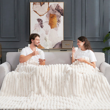 Couple relaxing on sofa with Cozy Bliss white faux fur blanket  #color_Cream White