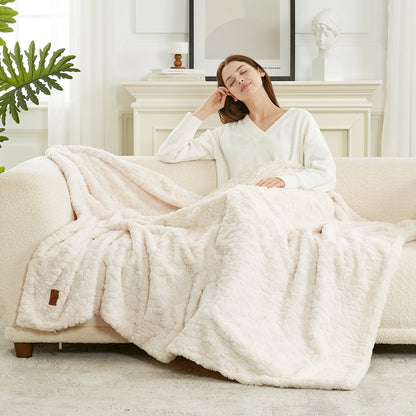 Woman relaxing on a couch under a fluffy white blanket in a cozy living room. #color_Cream White