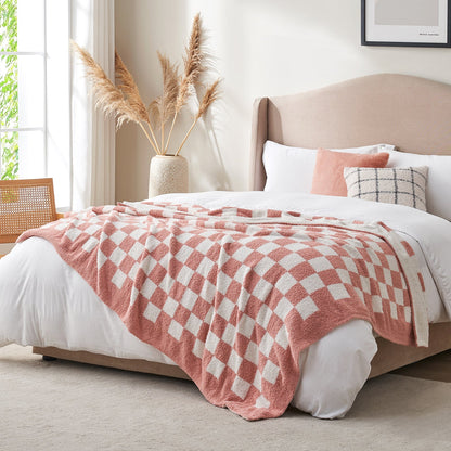 Checkered Feather Yarn Knit Throw Blanket in Pink styled on a bed in a modern bedroom. #color_Pink