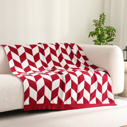 Chevron Feather Yarn Knit Throw Blanket in Red draped over a sofa, creating a warm atmosphere. #color_Red