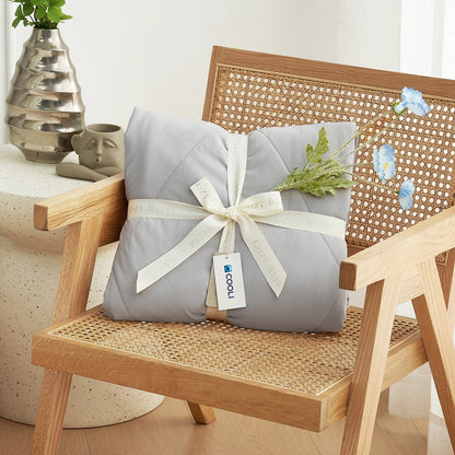 Cozy Bliss cooling comforter, perfect gift wrapped on chair #Color_Light Grey