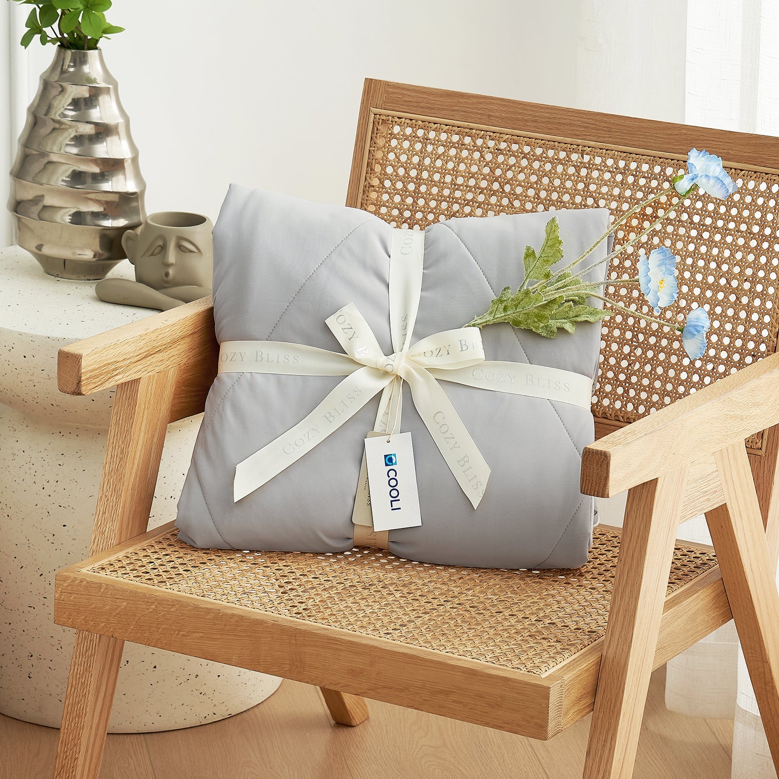Cozy Bliss cooling comforter, perfect gift wrapped on chair #Color_Light Grey