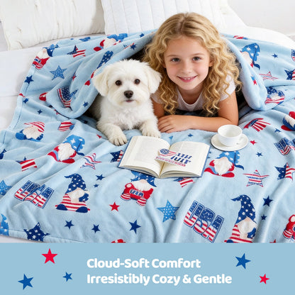 Child and dog under a patriotic-themed blanket with a book and cup on a bed.#color_Blue