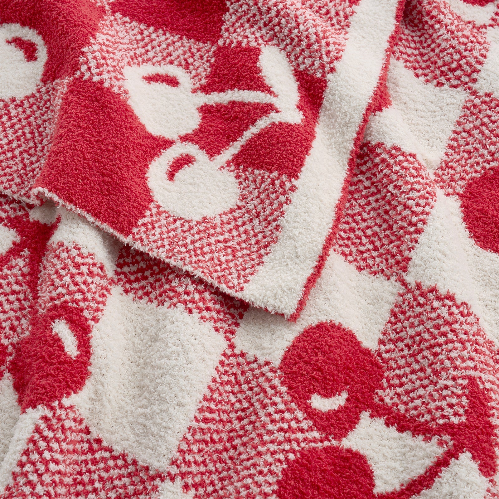 Close-up of cherry pattern on Reversible Checkered With Red Cherry Throw Blanket in Red Cherry highlighting soft feather yarn texture and plush feel. #color_Red Cherry