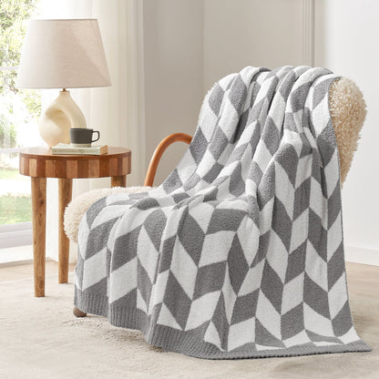 Chevron Feather Yarn Knit Throw Blanket in Grey draped over an armchair, showcasing soft feather yarn texture and chevron pattern design. #color_Grey