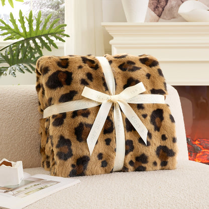 Fluffy brown leopard blanket with a bow on a couch. #Color_ Brown Leopard
