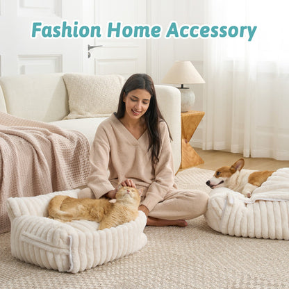 Woman sitting besides pet beds in a cozy living room.#color_Cream White