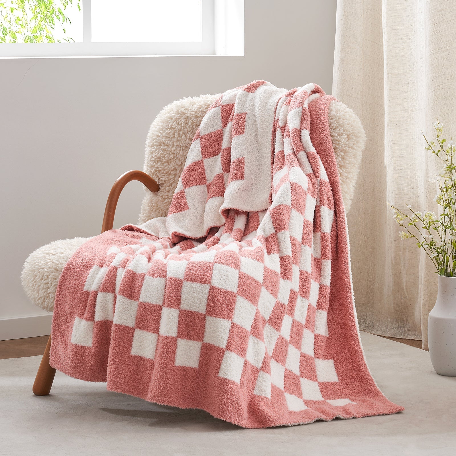 Checkered Feather Yarn Knit Throw Blanket in Pink front view draped over a chair, showcasing soft texture and checkered pattern design. #color_Pink
