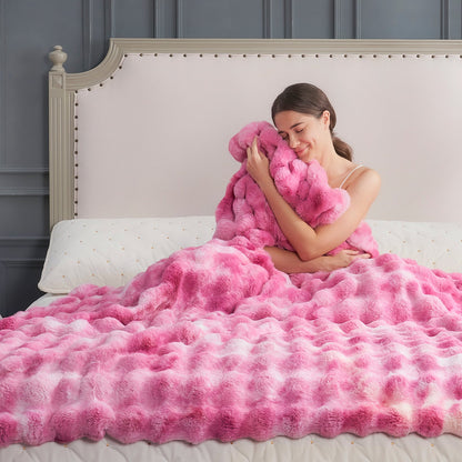 Woman wrapped in a fluffy tie-dye pink faux fur blanket on a bed. #color_Tie-dye Pink