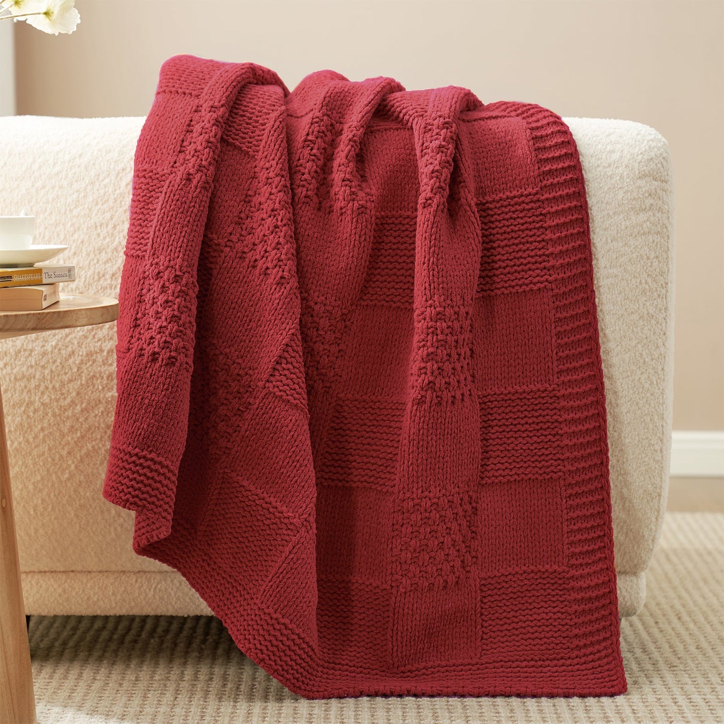 Checkered Chenille Knit Throw Blanket in Red draped over a sofa, highlighting soft chenille texture and detailed checkered knit design. #color_Red