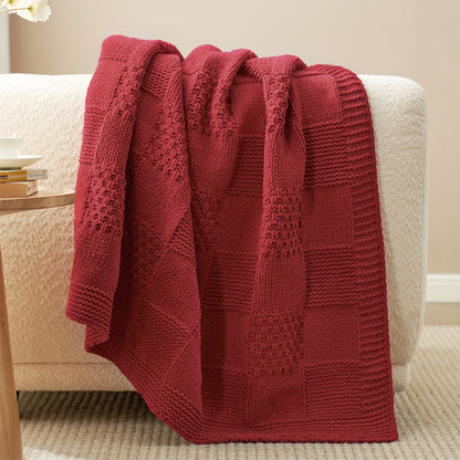 Checkered Chenille Knit Throw Blanket in Red draped over a sofa, highlighting soft chenille texture and detailed checkered knit design. #color_Red