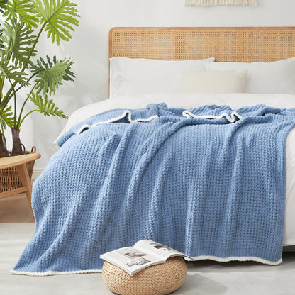Soft Waffle Feather Yarn Throw Blanket in Denim Blue styled on a bed, adding a modern and cozy layered look. #color_Denim Blue