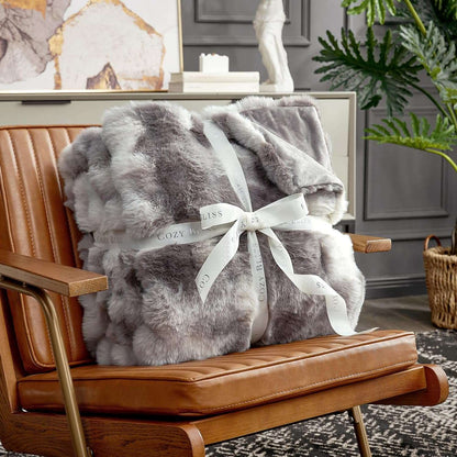 Fluffy tie-dye taupe blanket with a bow on an armchair. #color_Tie-dye Taupe