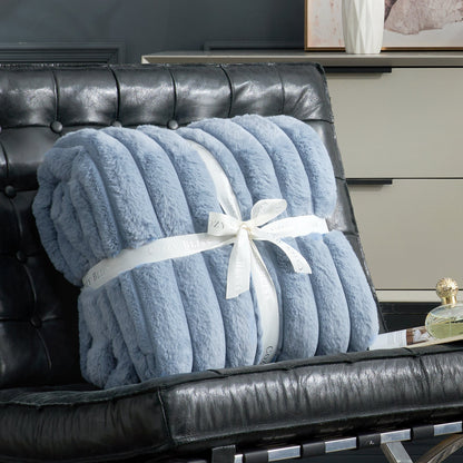 Fluffy blue striped faux fur throw blanket with a bow on a sofa. #color_Misty Blue