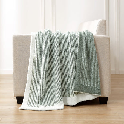 Soft Ribbed Feather Yarn Throw Blanket in Sage Green & White draped over the back of a sofa, highlighting soft ribbed texture and cozy fabric feel. #color_Sage Green & White